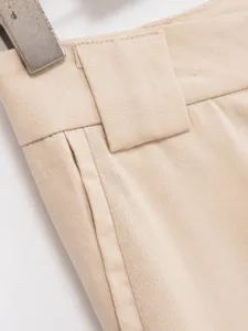 Detailed shot of beige trousers waistband, fine fabric texture, elegant commute style design.