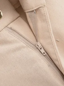 Close-up detail of women's beige casual trousers zipper, showing fine stitching and fabric texture.