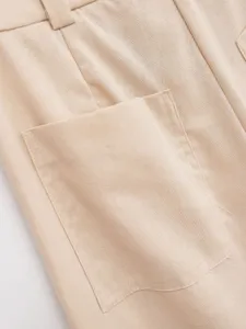 Detail shot of women's casual wide leg trousers pocket and fabric texture in light beige color.