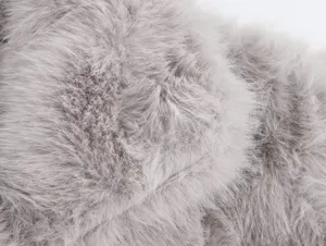 Detailed view of grey faux fur coat fabric, showcasing soft and fluffy texture quality.