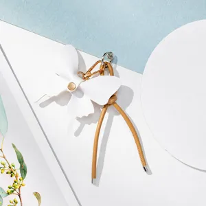 Detalle de dije de bolsa de lazo de cuero blanco, elegante cadena de teléfono.