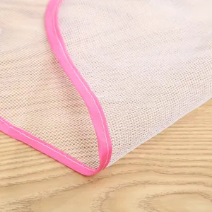 Primo piano dettaglio del panno da stiro in rete bianca con bordo rosa su superficie in legno.