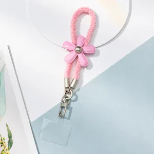 Détail en gros plan de la jolie sangle de charme de téléphone fleur peluche rose.