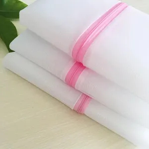 Fine mesh laundry bag detail showing durable white fabric and smooth pink zipper closure.