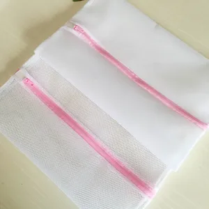 Sac à linge en maille fine avec fermeture éclair rose pour vêtements délicats, détail.