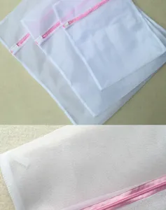 White mesh laundry bags with pink zippers, durable multi-size set detail view for clothes.
