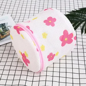Cylindrical mesh laundry bag with pink flower pattern and zipper for delicate underwear protection.