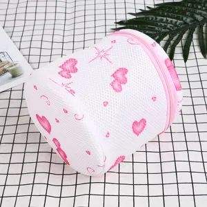 Cylindrical thickened mesh laundry bag detail, pink heart print and secure zipper closure.