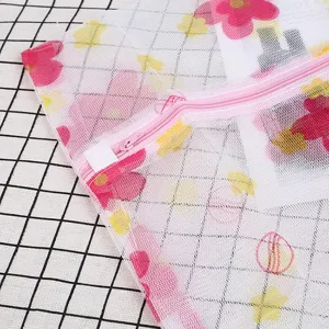 Gros plan sur le grand sac de lavage en filet imprimé avec fermeture éclair rose.