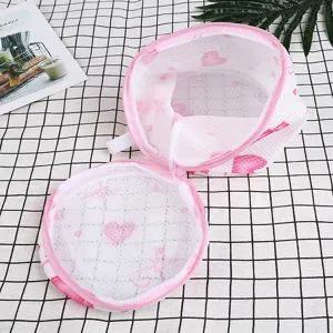 Cylindrical thickened sandwich mesh laundry bag with pink heart print for washing bras.
