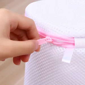 Close-up detail of white mesh laundry bag with pink zipper for delicate underwear wash.