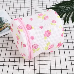 Cylindrical mesh laundry bag with pink zipper and rose pattern for delicate underwear washing.