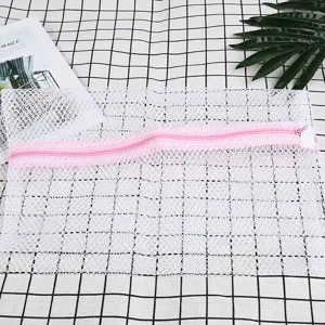 Bolsa para lavadora de malla blanca con cremallera rosa para ropa delicada detalle.