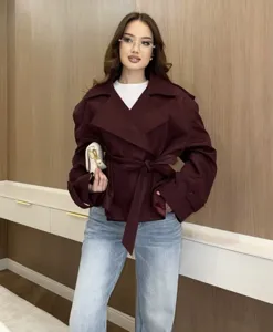 Stylish short trench coat in burgundy, paired with blue jeans for a chic commuter look.