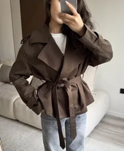 Detail shot of stylish brown short trench coat with belt, ideal for casual and commuting wear.