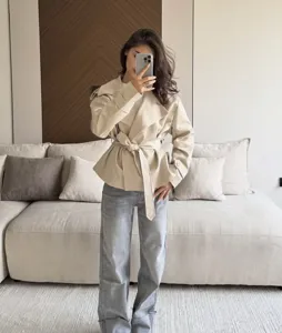 Short beige trench coat for women with lapel collar and waist belt, casual daily wear.