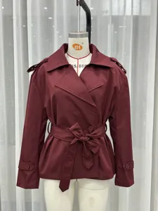 Detail view of the burgundy short trench coat featuring a classic lapel and matching waist belt.