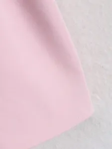 Close-up fabric detail of women's pink trench coat showing fine twill weave and smooth texture.