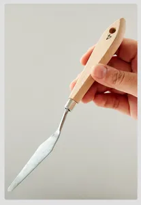 Primer plano de espátula de pintura artística, cuchilla de acero inoxidable con mango de madera.
