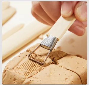 Professional pottery clay carving tool with wooden handle and metal loop for ceramic art.