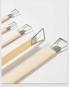 Detailed view of pottery sculpture tools with wooden handles and serrated wire loops.