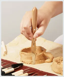 Detailopname van aardewerk boetseergereedschap met houten handvat dat klei snijdt. Ideaal DIY.