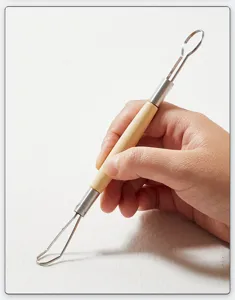 Dettaglio dello strumento per scultura in argilla a doppia estremita con manico in legno.