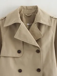 Short double-breasted trench coat jacket detail featuring classic lapel collar and tortoise buttons.
