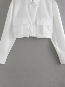 Detail view of the white crop utility shirt featuring dual front pockets, lapel collar and long sleeves.