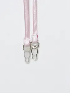 Close-up detail of pink satin garment straps with metallic and plastic adjustable clips.