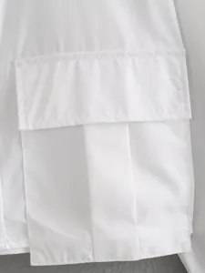 Close-up detail of white long-sleeve cargo shirt pocket, clean fabric texture and neat stitching.