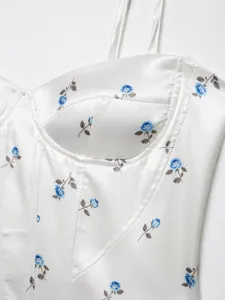 Close-up detail of white satin floral camisole top showing blue rose print and boning structure.