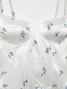 Detailed view of white satin camisole featuring blue rose floral print and boning seam design.