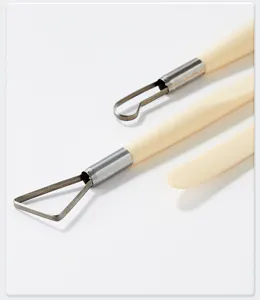 Detailed view of pottery clay sculpting tools with metal wire heads and smooth handles.