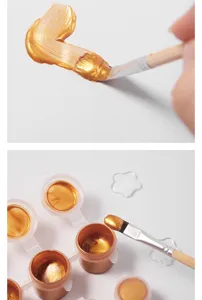 Gouden acrylverf set detail met gladde metallische textuur en pigment potjes erbij.