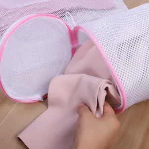 Detailed close-up of a white mesh laundry bag with pink zipper, showing interior structure.