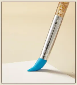 Close-up detail of silicone painting brush with blue tip and glitter handle, fine art tool.