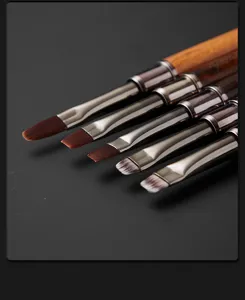 Vista di dettaglio di pennelli per nail art in legno a doppia punta con varie forme di setole.