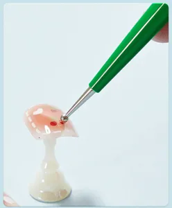 Detailed view of nail art dotting pen with green handle, perfect for precise manicure designs.