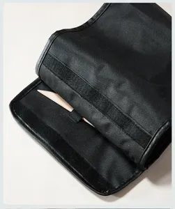 Detalle de estuche de lona para herramientas de cerámica con tela resistente y utensilios de madera.