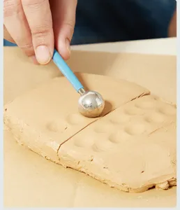 Herramienta de escultura de arcilla con mango azul para cerámica DIY y modelado.