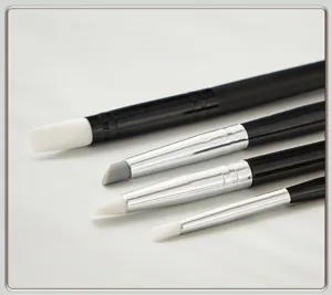 Primo piano dettagliato di pennelli per intaglio unghie in morbido silicone con manici neri.
