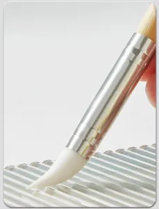 Close-up detail view of soft silicone pottery clay sculpting brush with wooden handle.