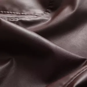 Detailaufnahme von dunkelbraunem Kunstlederjackenstoff mit feiner Textur und sauberer Naht.