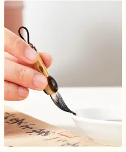 Close-up van een prachtige mini kalligrafiepenseel met bamboe handvat en zachte haren.