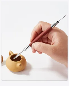 Primer plano detallado de una herramienta de escultura de cerámica con mango.