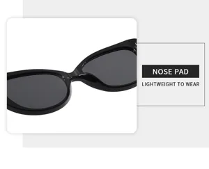 Detalle de gafas de sol ovaladas vintage, montura negra con almohadilla nasal ligera.