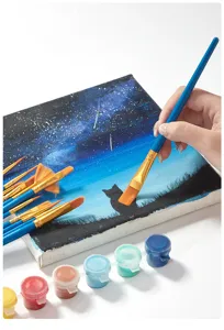 Primer plano de pinceles de nailon para arte con tarros de pintura acrílica y lienzo.