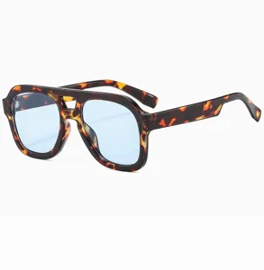 Gros plan détaillé de lunettes de soleil carrées écaille avec double pont et verres bleus.
