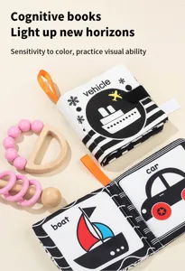 Black and white infant cognitive cloth book detail with wooden teether rattle toy.